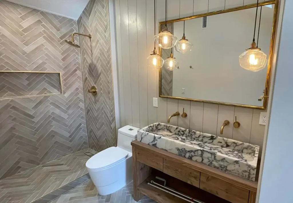Bathroom remodel including new plumbing fixtures, tile, sink, vanity and toilet.