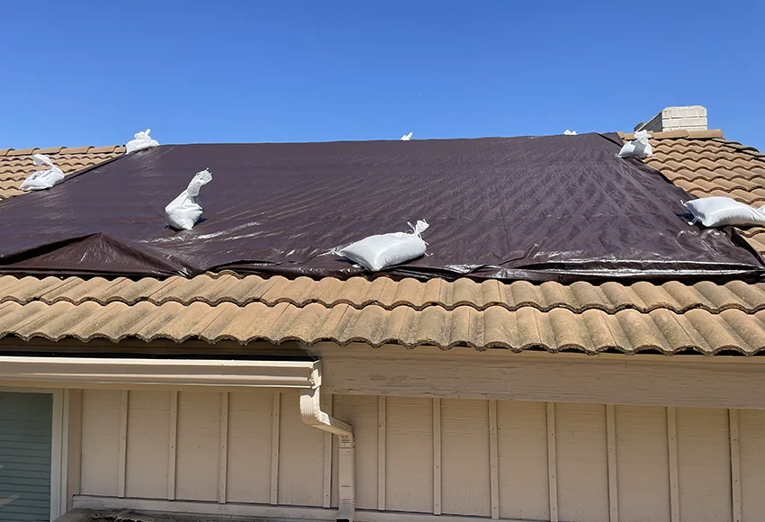 Tarp covering roof leak to be repaired