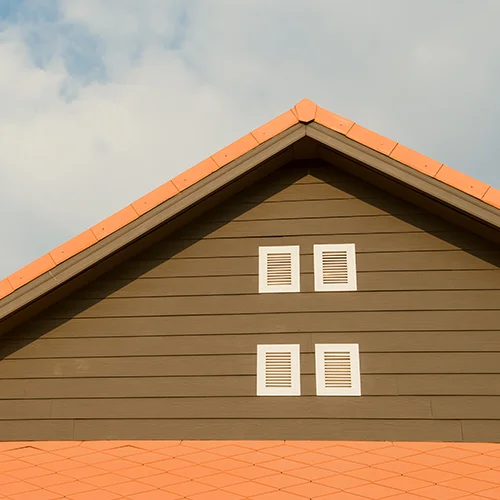 Four white gable vents installed beneath the peak of a residential roof.