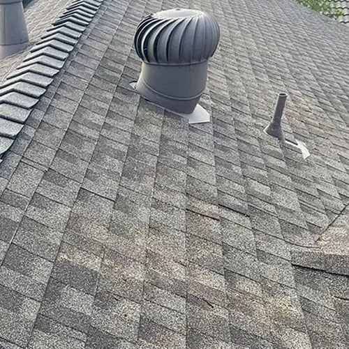 Wind-driven metal turbine attic vent installed on a residential asphalt shingle roof
